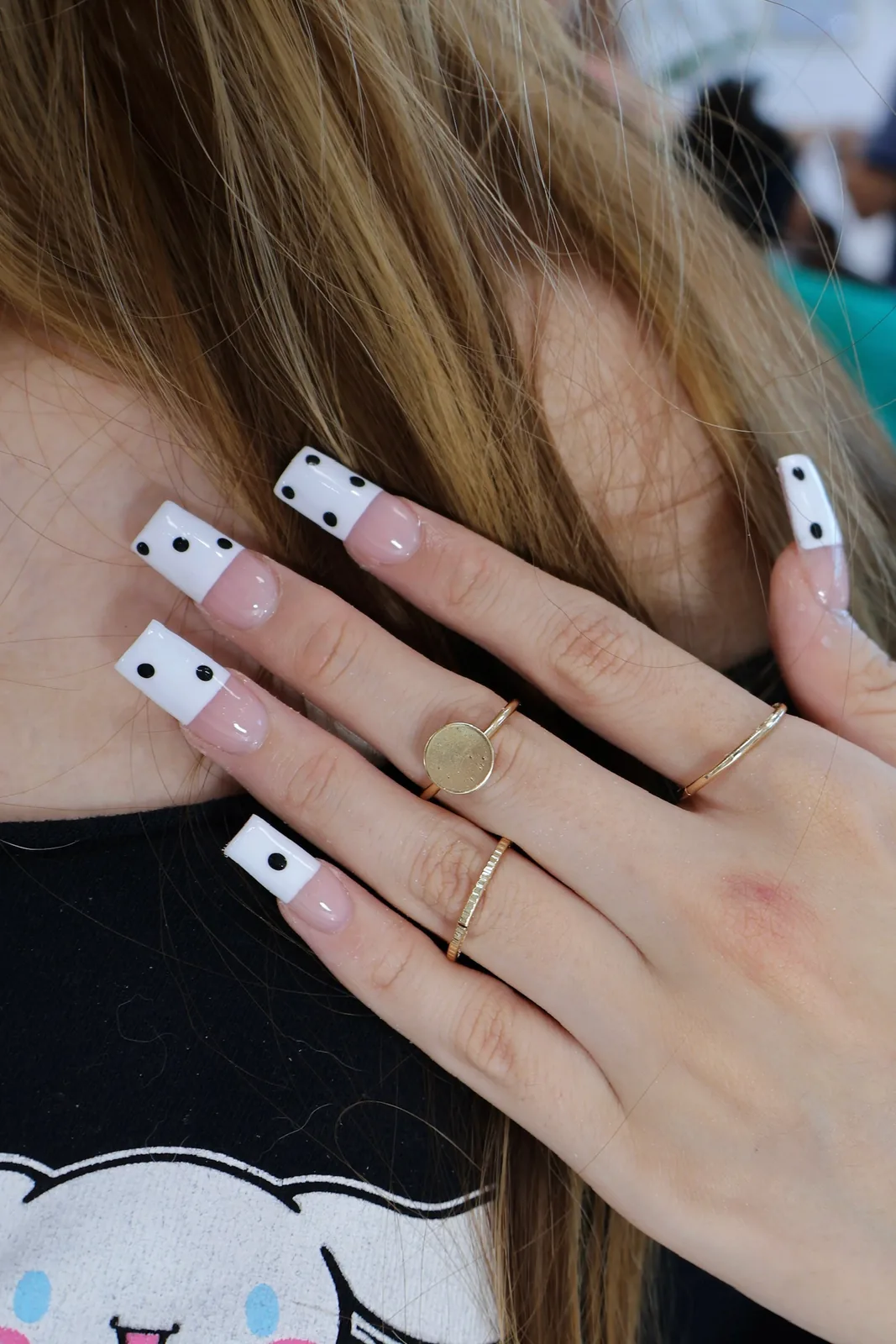 Close-up of white French tips with black dot nail art