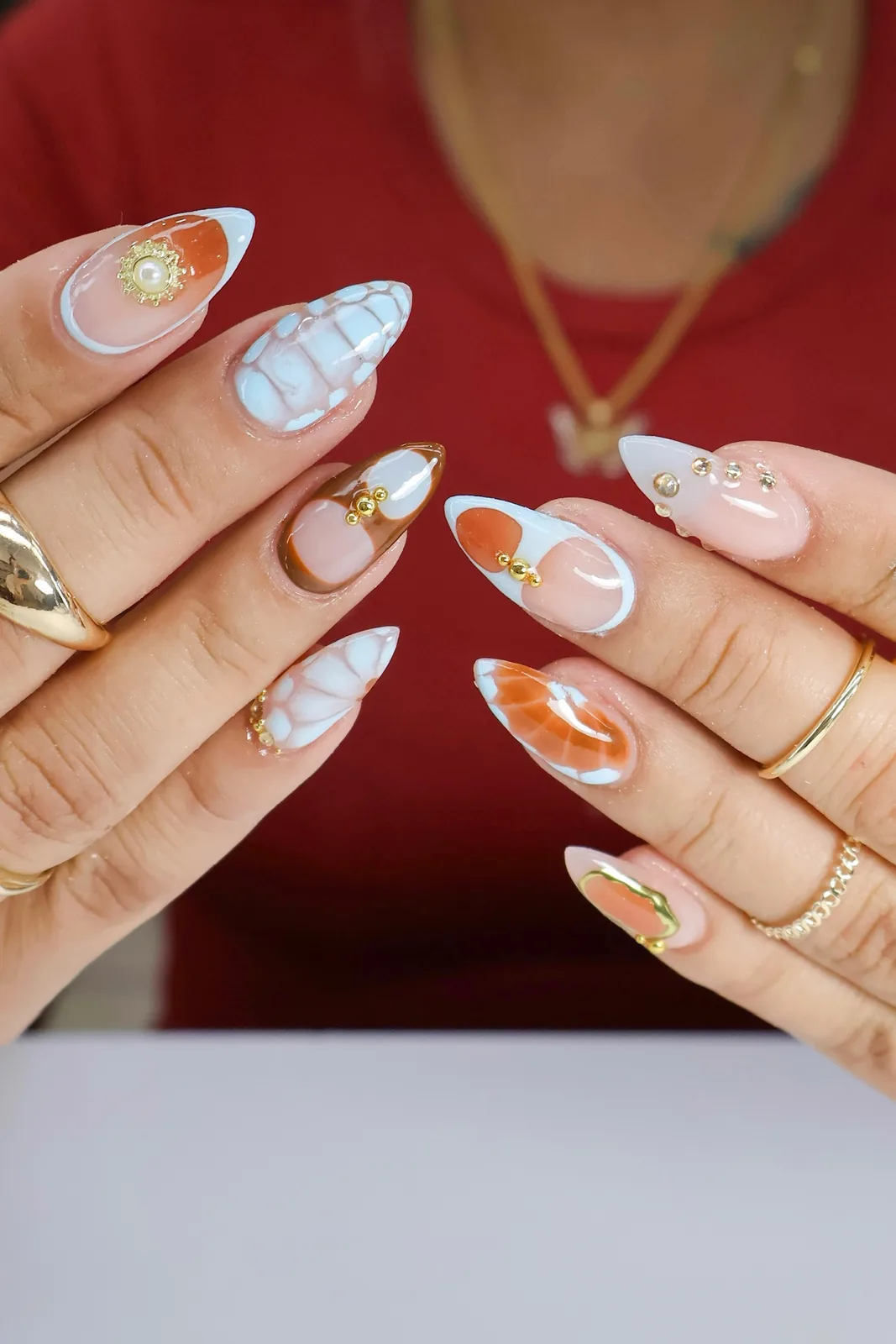 Close-up of black French tip nails with pink flowers and rhinestone details