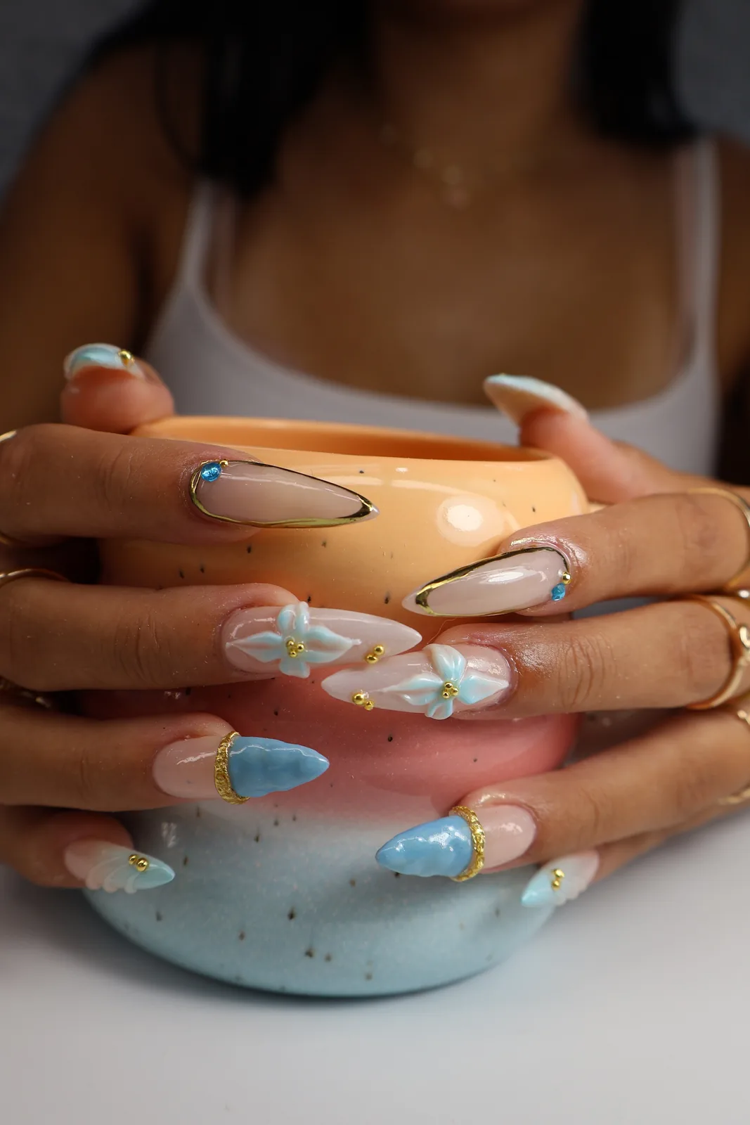 Blue 3D flower stiletto nails holding a pastel ombre mug