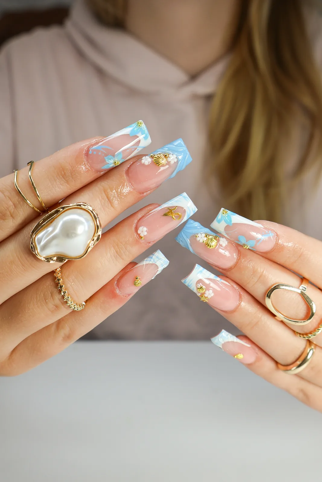 Sky-blue French square nails with gold foil flakes and pearl accents