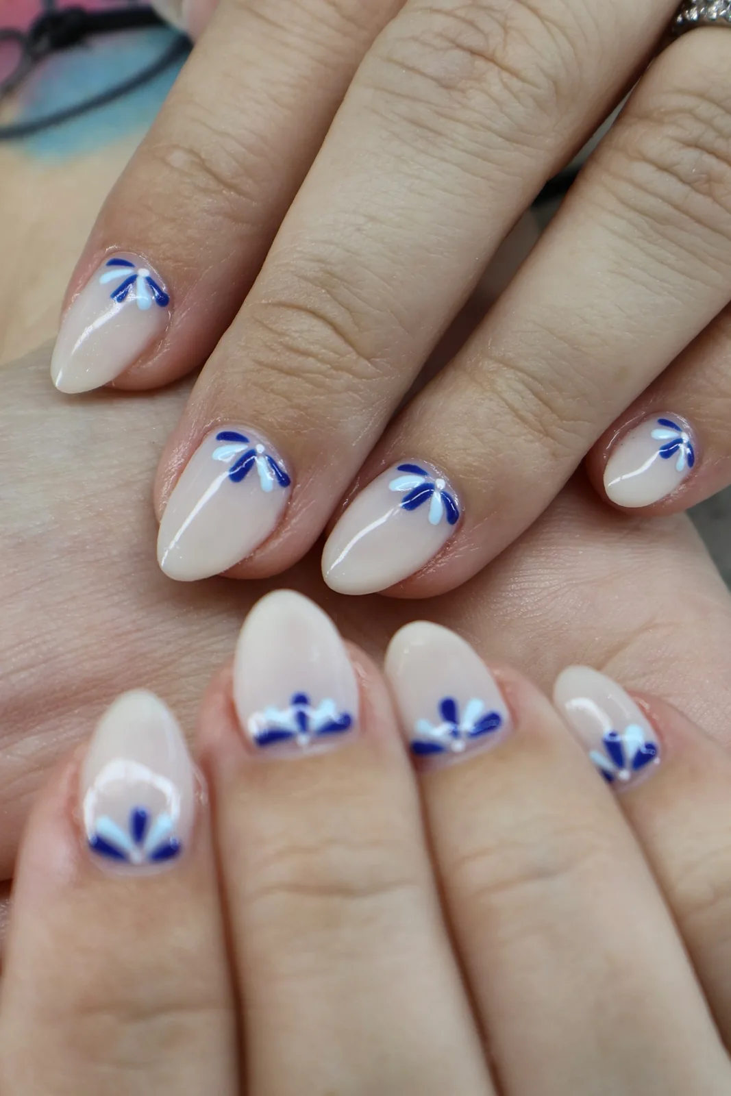 Short milky almond nails with delicate blue petal accents