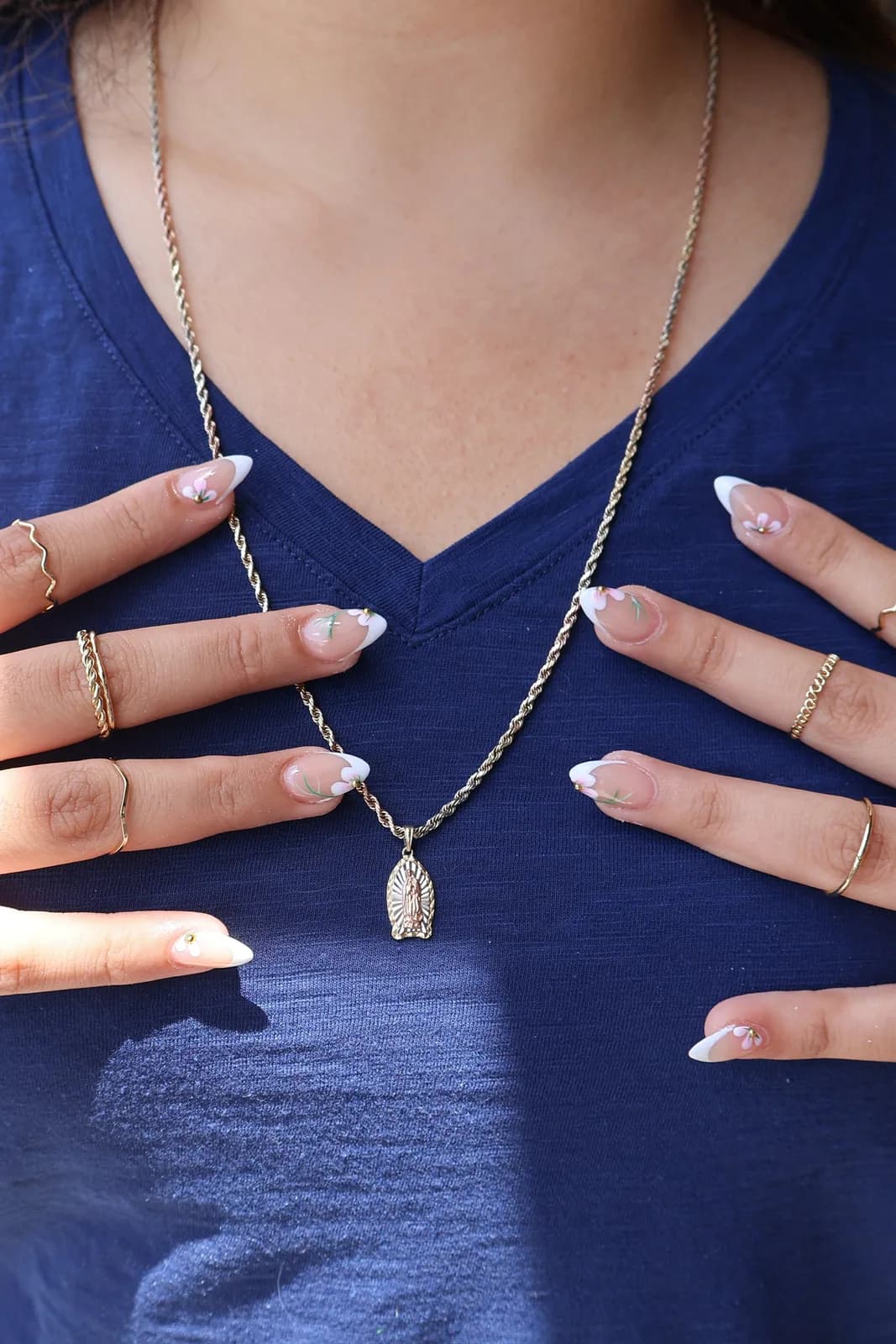 Delicate white French nails with small accents, worn with a chain necklace