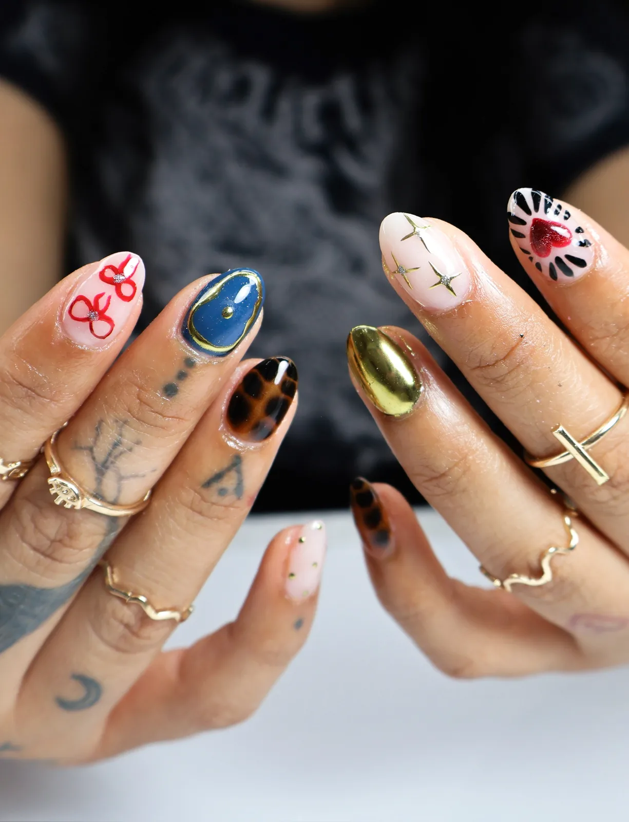 Eclectic almond nail set mixing gold chrome, navy, tortoiseshell, and heart art