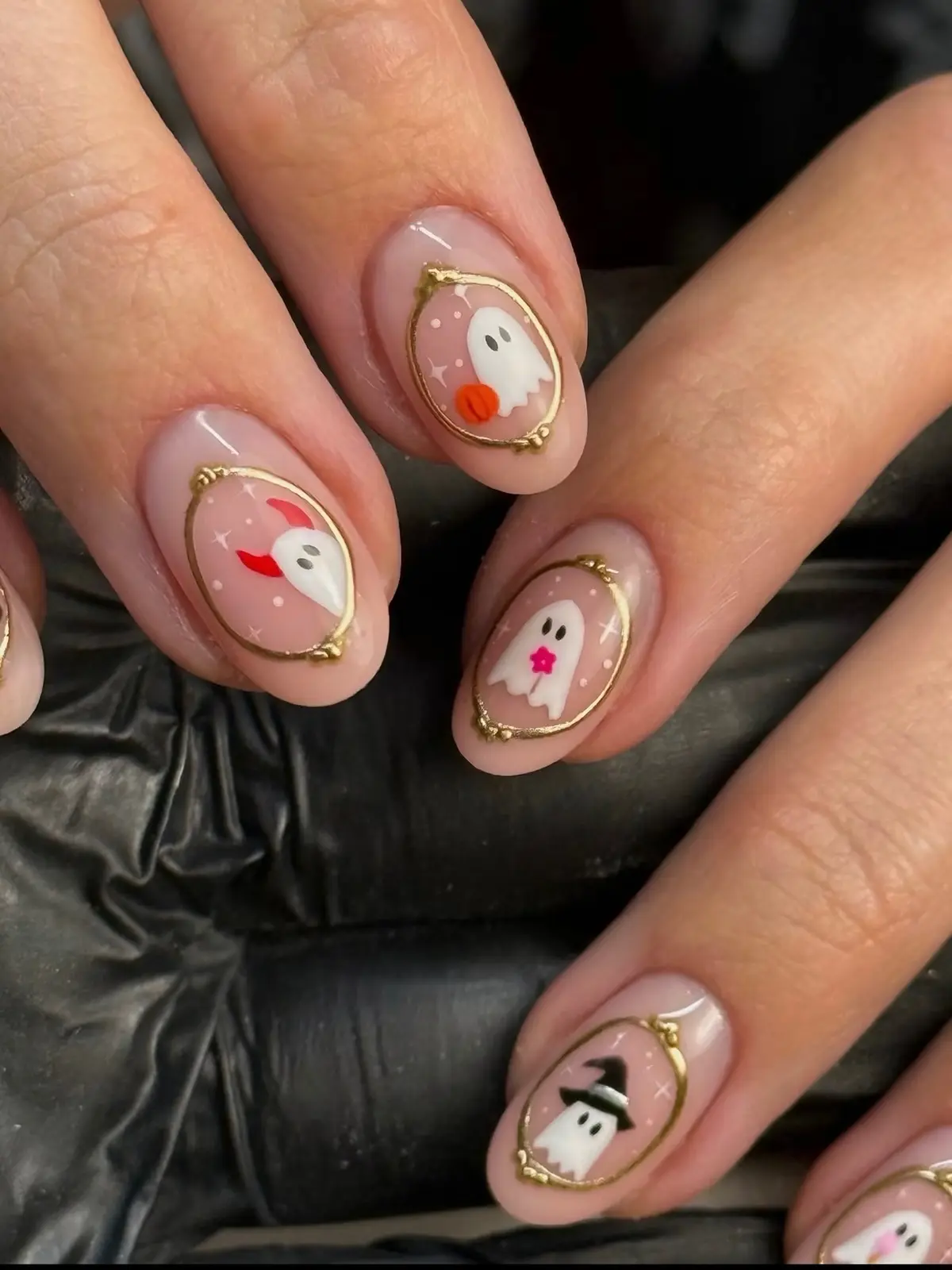 Close-up of gold-framed ghost portrait nails with a devil-horn ghost, a flower ghost and a witch-hat ghost