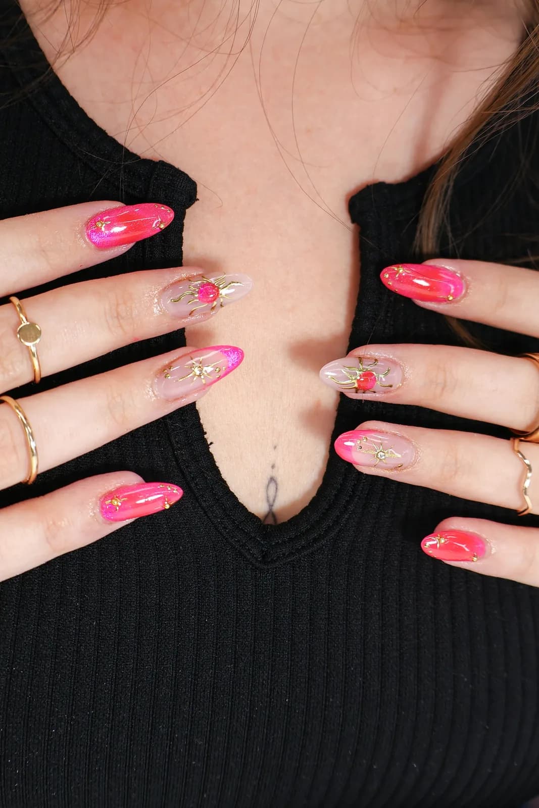 Hot-pink and sheer glitter almond nails with gold charm details