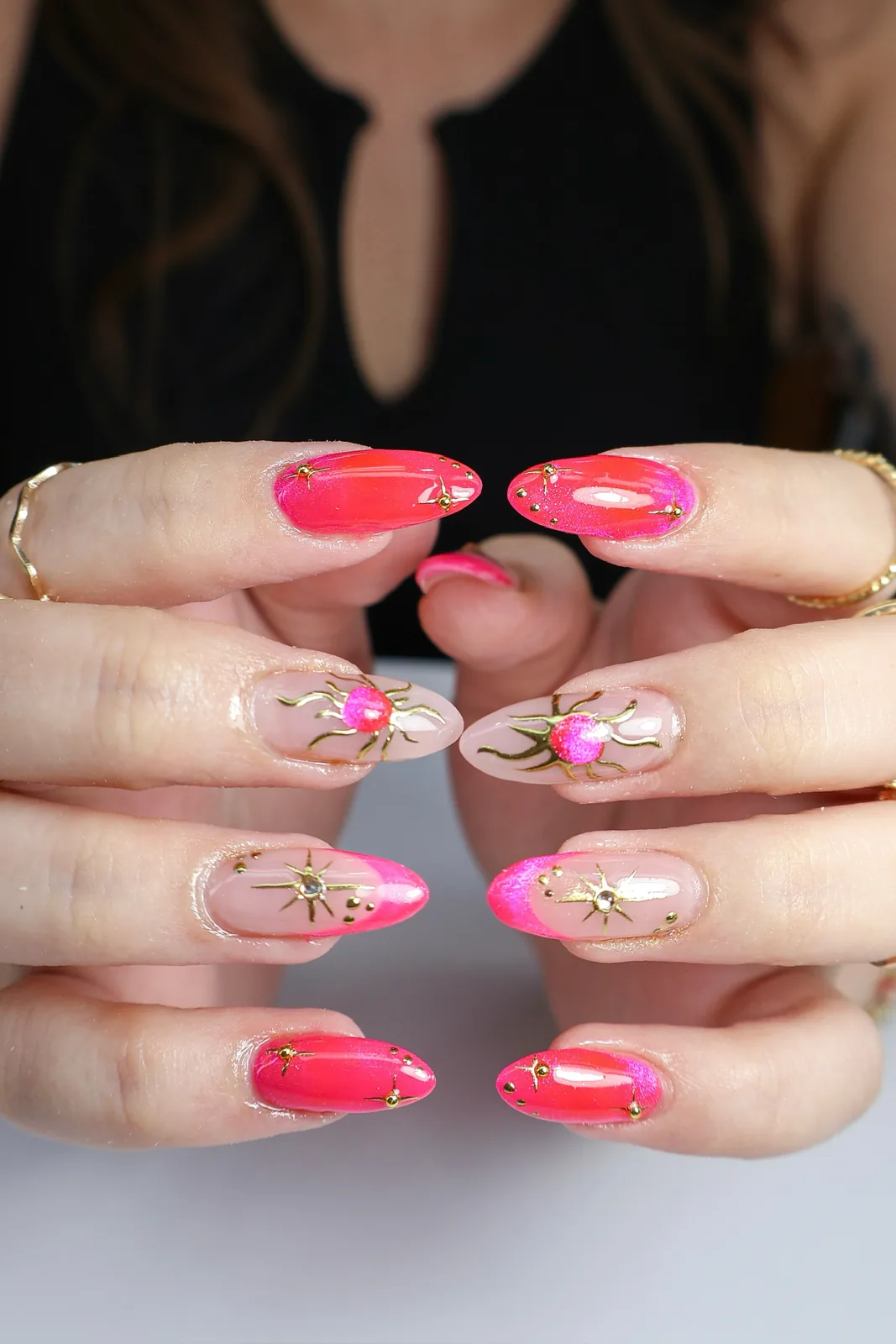 Hot-pink and sheer almond nails with gold star and rosebud nail art