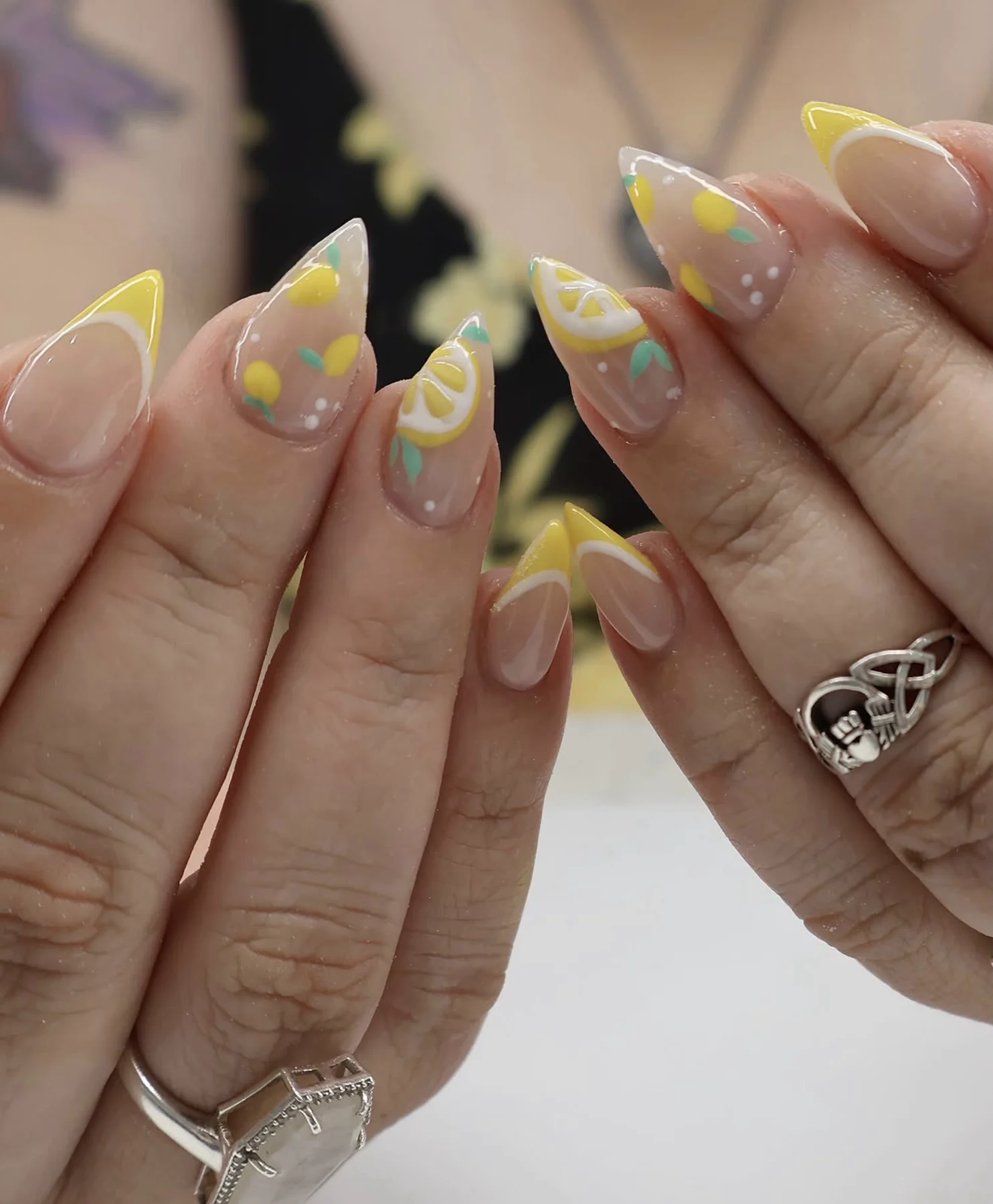 Clear almond nails with yellow French edges and painted lemon slices