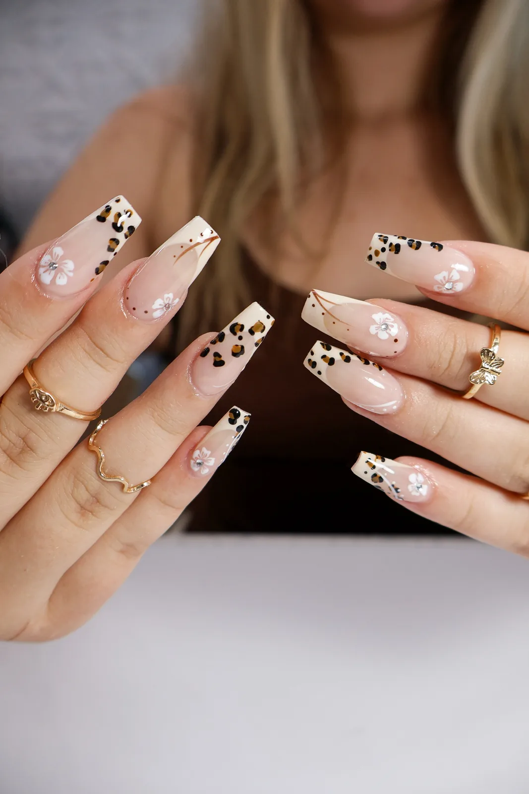 Both hands showing leopard print and floral French coffin nails