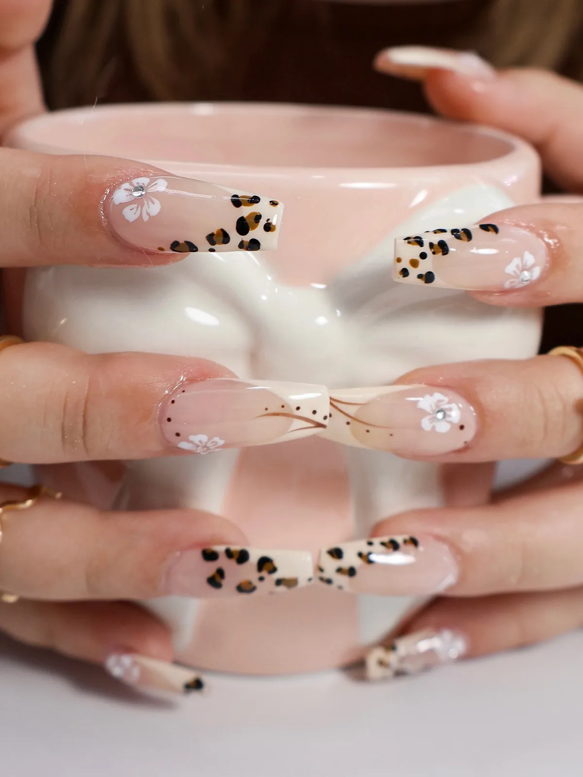 Leopard and flower French nails holding a pink bow mug