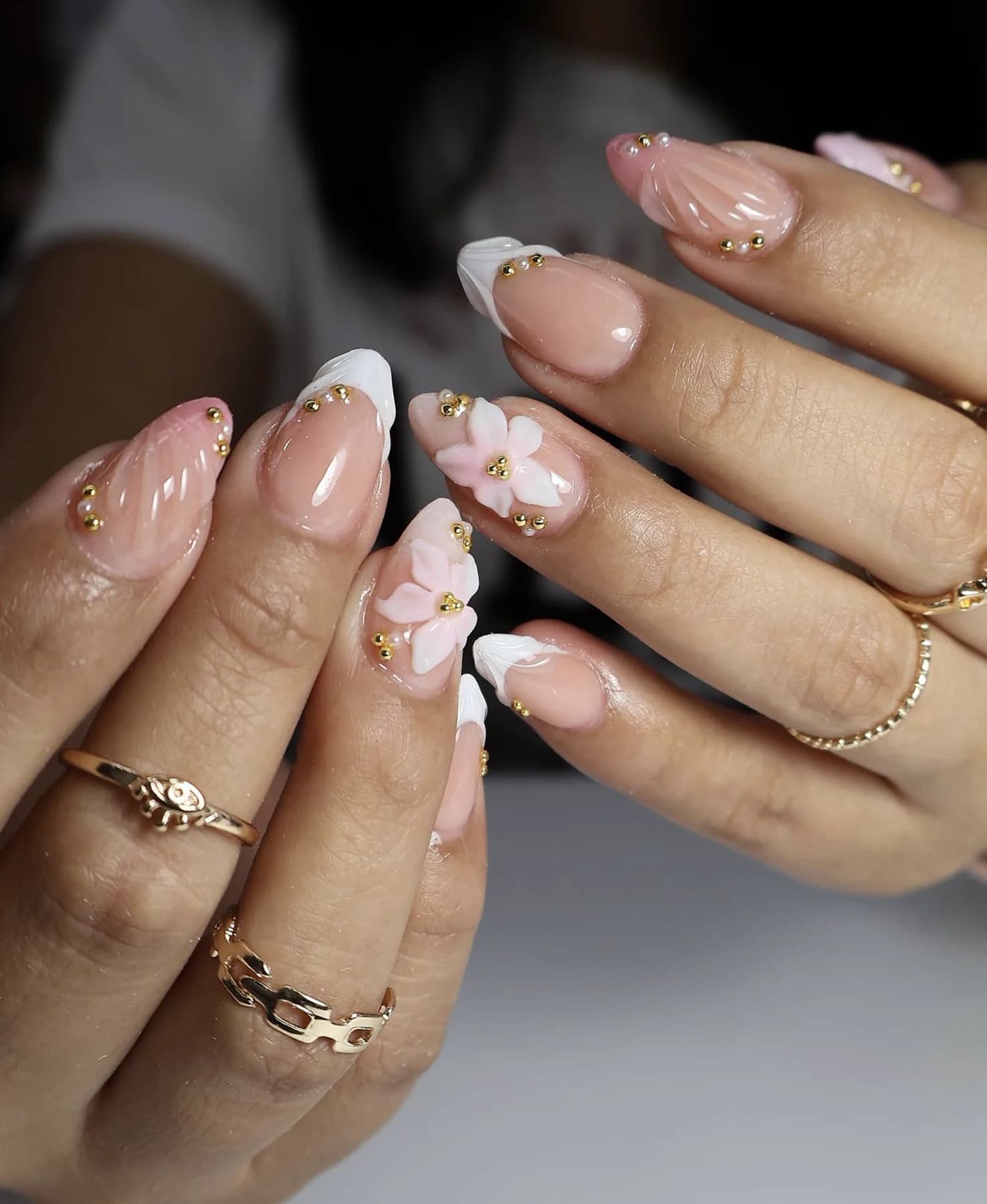 Sheer pink almond nails with white French tips and 3D flower accents