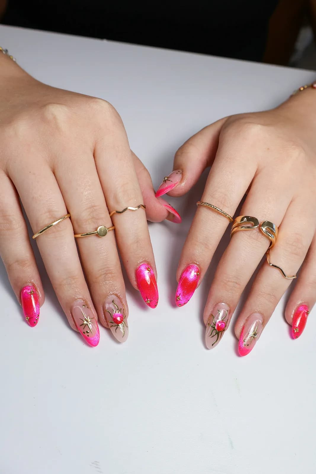 Metallic pink chrome French tips with hand-painted flowers, done at King & Queen Nails & Spa
