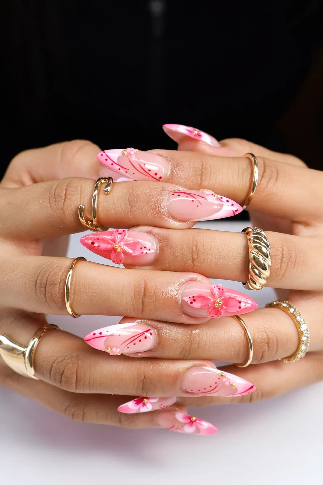 Pink French almond nails with hand-painted flowers and dotted vines