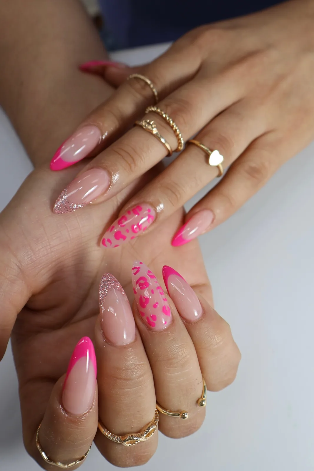 Hot-pink French almond nails with pink leopard print and glitter accents