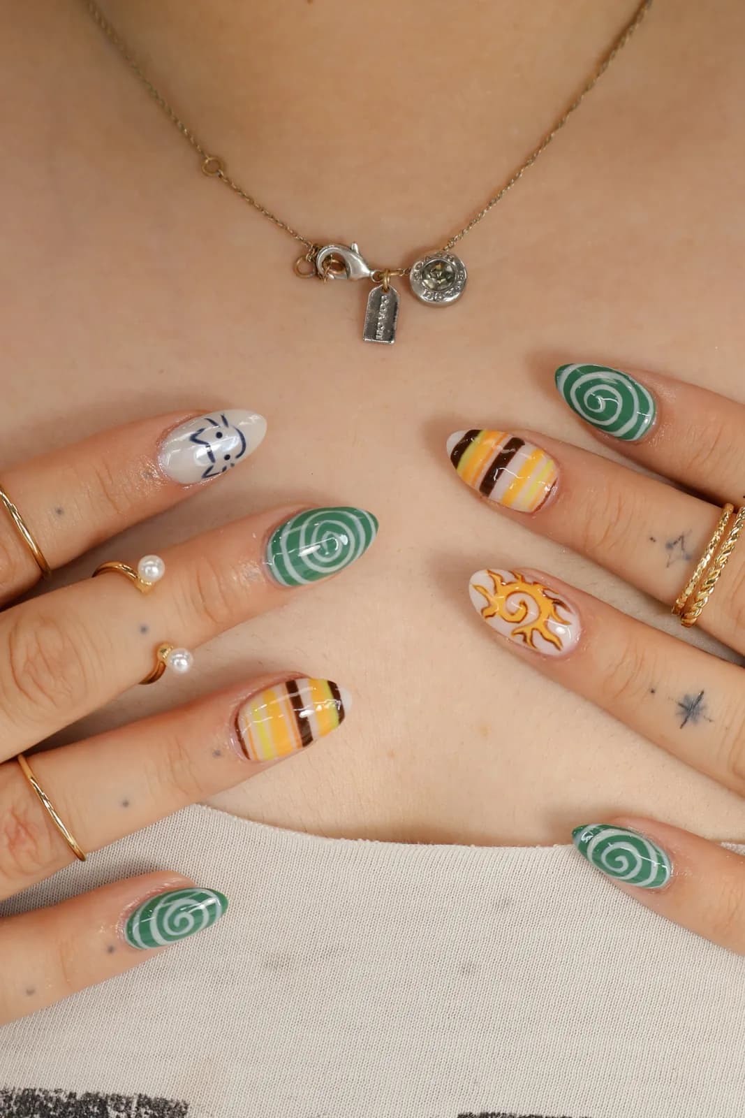 Full retro nail set with green swirls, candy stripes, and sun accents