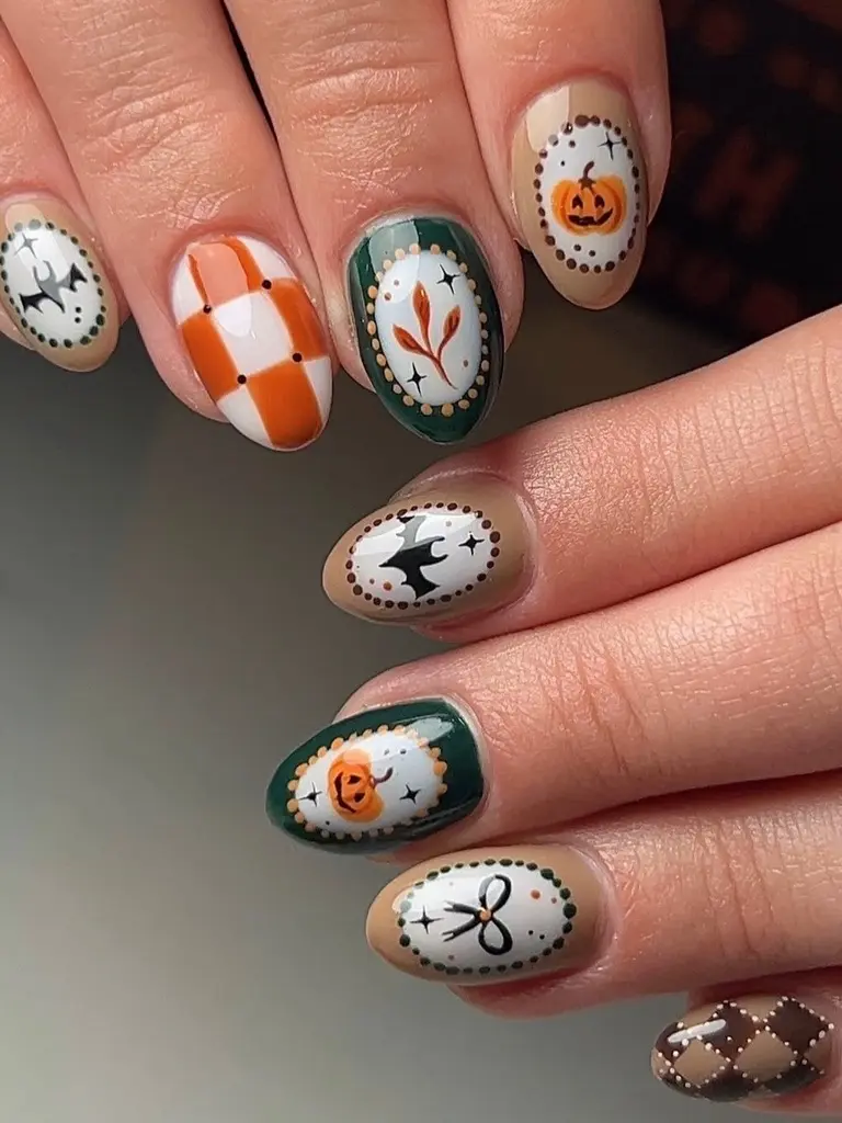 Both hands with cameo-frame Halloween nails: jack-o’-lanterns, bats, a bow and a leaf sprig, plus orange checkerboard and brown argyle accents