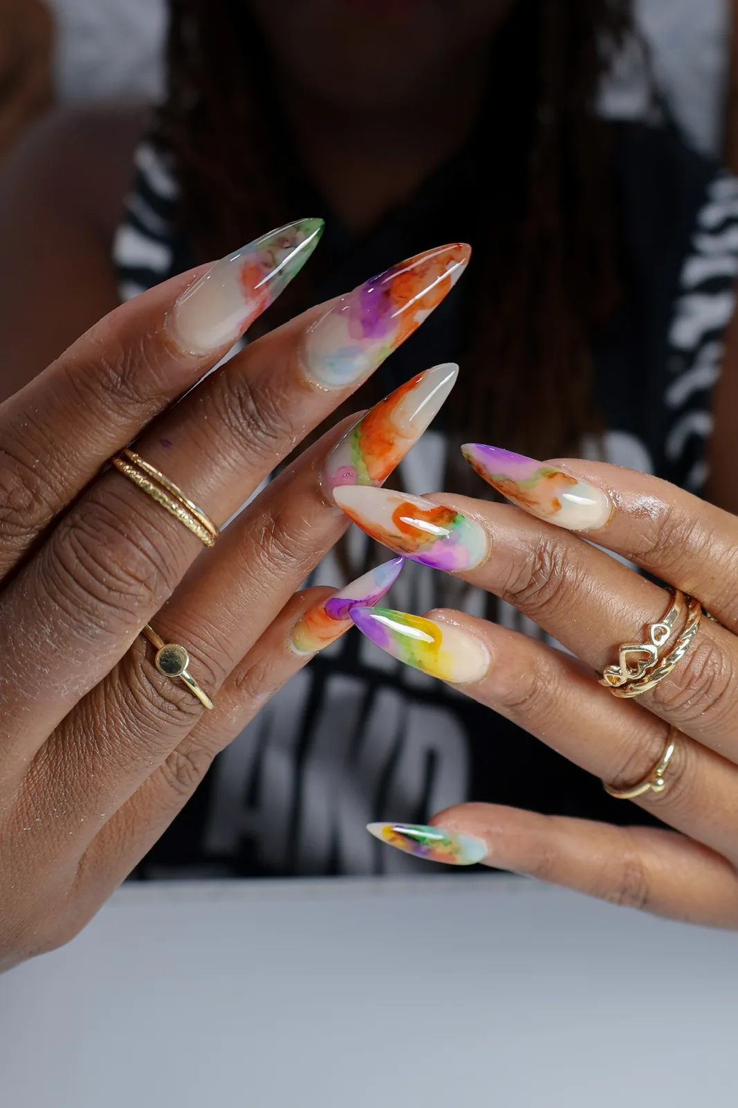 Extra-long stiletto nails with watercolor floral art in orange, purple, and green