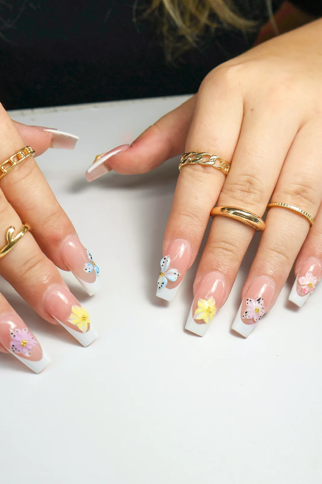 White French tip coffin nails with pastel daisy and butterfly nail art