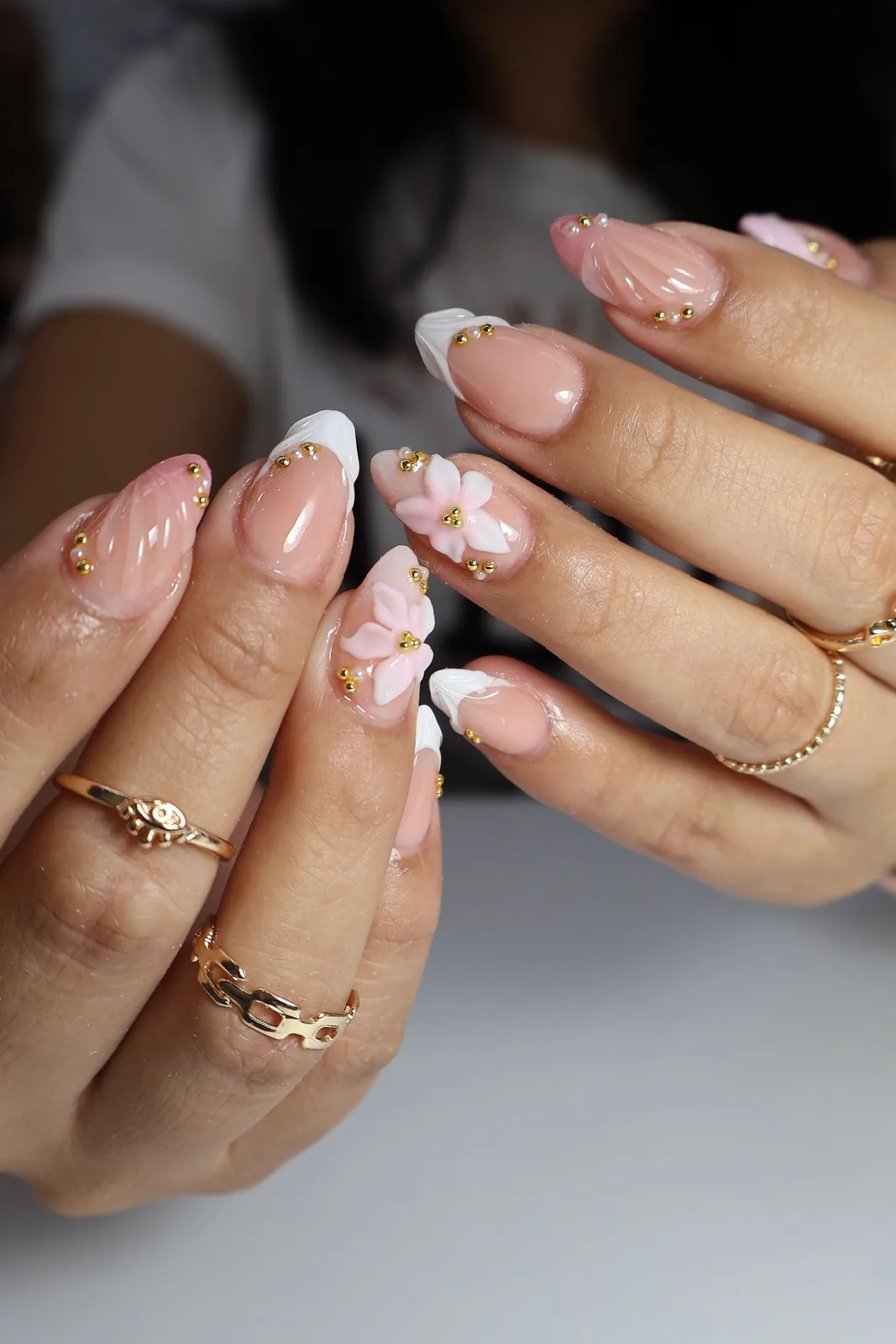 White French almond nails with pink 3D flowers and gold bead details
